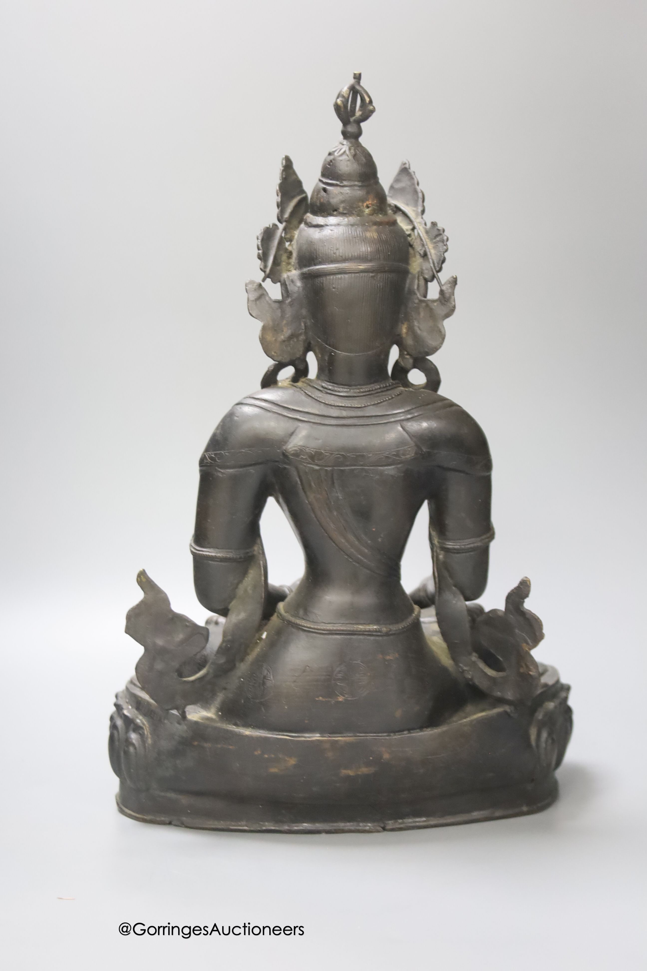 A bronze figure of a Bodhisattva, seated on an oval lotus base, 36cm